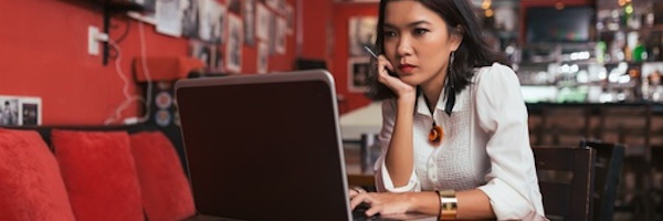 Girl sitting at bar with laptop